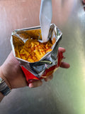 Frilokos PIFAS servidos en una bolsa de chips con maíz, queso cheddar y salsas. Fotografía original del negocio.